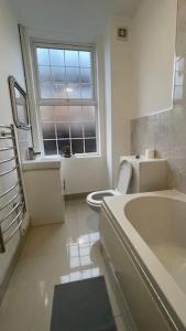 uma casa de banho branca com um WC e uma janela em Suite 1- Luxury 1 Bed Apt- Leicester City- Free Parking em Leicester