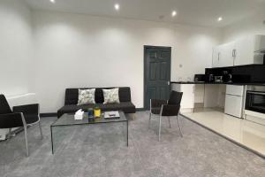 a living room with a couch and a table and chairs at Suite 1- Luxury 1 Bed Apt- Leicester City- Free Parking in Leicester