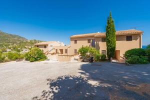 a house with a large driveway in front of it at T2 vue mer à Saint-Clair in Le Lavandou