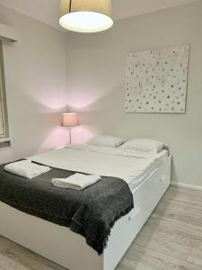 biała sypialnia z łóżkiem z czarnym kocem w obiekcie Charming Central Apartment Helsinki w Helsinkach