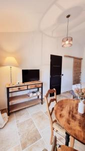 sala de estar con mesa y TV en Suite Oasis en Provence Luberon Pierrevert en Pierrevert