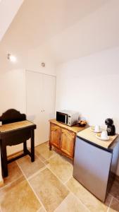 a kitchen with a table and a microwave on a counter at Suite Oasis en Provence Luberon Pierrevert in Pierrevert