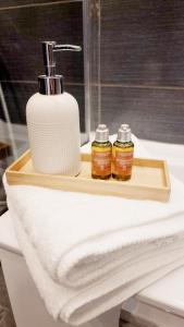 - un lavabo dans la salle de bains avec un distributeur de savon et une serviette dans l'établissement Suite Oasis en Provence Luberon Pierrevert, à Pierrevert