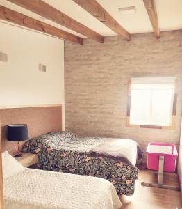 1 dormitorio con 2 camas y ventana en Altavista comodidad modernidad y seguridad en Ranco