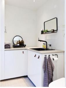 ein Badezimmer mit weißen Schränken, einem Waschbecken und einem Spiegel in der Unterkunft Bokis - Modern Forest Cottage in Brösarp