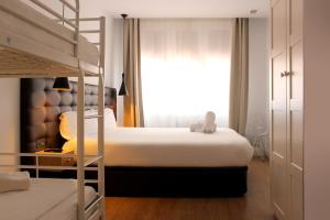 1 dormitorio con 2 literas y ventana en Woohoo Suites Madrid, en Madrid