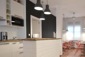 a kitchen with white cabinets and a table with chairs at Woohoo Suites Madrid in Madrid