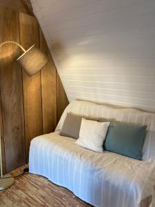 Bett in der Ecke eines Zimmers mit Lampe in der Unterkunft Grange Rousselin in Bachivillers