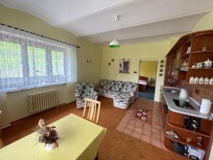 Ubytování v Krkonoších, rodinný apartmán Peklíčko في Horní Lánov: مطبخ وغرفة معيشة مع أريكة وطاولة