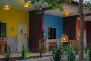 a house with colorful walls and a white door at Muda Hotel in Tianguá