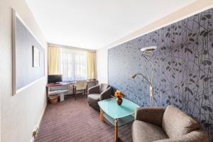 a living room with a couch and a table at Hotel Forstmeister in Schönheide