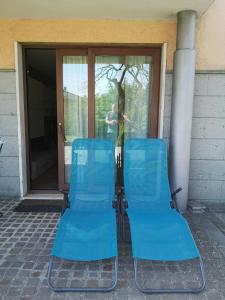 duas cadeiras azuis em frente a uma porta de vidro em Casa Mica em Abbadia San Salvatore