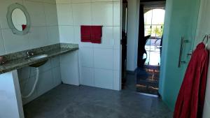 ein Bad mit einem Waschbecken und einem roten Handtuch in der Unterkunft Tabatinga Relax Apartamentos in Conde
