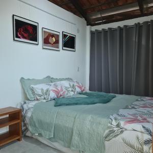 ein Schlafzimmer mit einem Bett mit einer grünen Bettdecke in der Unterkunft Tabatinga Relax Apartamentos in Conde