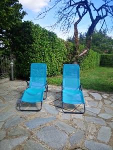 2 sillas azules sentadas en un patio de piedra en Casa Mica en Abbadia San Salvatore