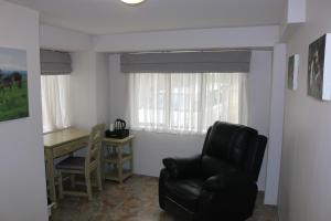 a living room with a black chair and a desk at Livivane Guest House in Simunye