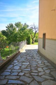 een stenen loopbrug naast een gebouw met een hek bij Casa Mica in Abbadia San Salvatore