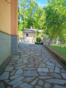 a stone walkway in front of a building with a fence at Casa Mica in Abbadia San Salvatore