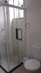 uma casa de banho com uma cabina de duche em vidro e um WC. em Apartamento à beira mar Praia de Unamar em Cabo Frio