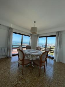 馬德普拉塔的住宿－Los Petos - Playa Grande，一间带桌椅和窗户的用餐室
