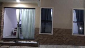 a room with three windows and a white curtain at Apartamento à beira mar Praia de Unamar in Cabo Frio