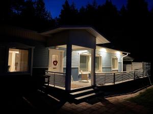 uma casa com um alpendre iluminado à noite em Blue Dream House em Rovaniemi