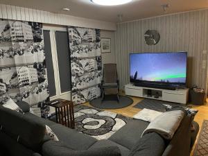 a living room with a couch and a flat screen tv at Blue Dream House in Rovaniemi