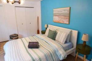 a blue bedroom with a bed with a purse on it at Harrison On The Lake, Walkable to Beach and Village in Harrison Hot Springs