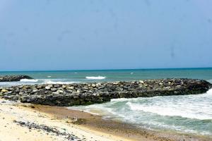 a beach with a pile of rocks and the ocean at Moven Paradise in Accra