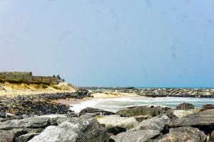 een strand met grote rotsen en de oceaan bij Moven Paradise in Accra