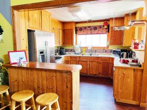 a kitchen with wooden cabinets and a counter with stools at Sarah's dreamhouse B&B in Churchill