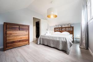 um quarto com uma cama grande e uma cómoda em madeira em Villa Kassav'ry em Capesterre-Belle-Eau