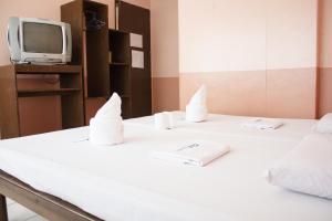 a room with two beds and a tv on a table at GV Hotel - Tacloban in Tacloban