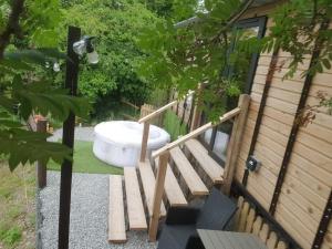 eine Badewanne und eine Treppe neben einem Haus in der Unterkunft The Horrrsebox Tinyhouse Glamping in Garadice