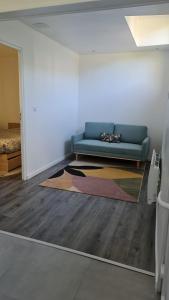 ein Wohnzimmer mit einem blauen Sofa und einem Teppich in der Unterkunft STUDIO COCON VERNON-GIVERNY in Vernon