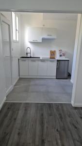 an empty kitchen with white cabinets and a sink at STUDIO COCON VERNON-GIVERNY in Vernon