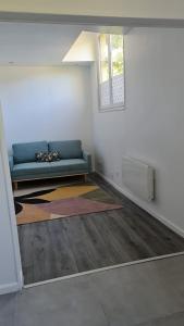 a living room with a blue couch and a window at STUDIO COCON VERNON-GIVERNY in Vernon