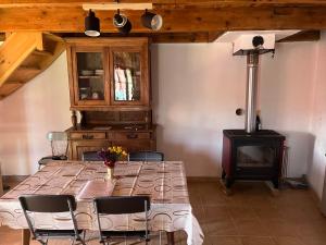 a dining room with a table and a wood stove at Le col de Perjuret in Fraissinet-de-Fourques