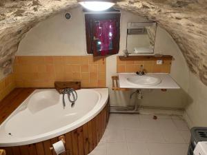 a bathroom with a bath tub and a sink at Le col de Perjuret in Fraissinet-de-Fourques