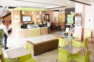 a restaurant with yellow chairs and tables and a counter at GV Hotel - Tacloban in Tacloban