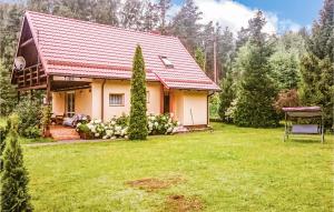 a small house with a red roof in a yard at Stunning Home In Golubie With Wifi in Gołubie