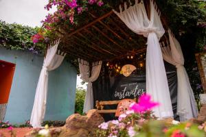 - un pavillon avec des rideaux blancs et des fleurs roses dans l'établissement Muda Hotel, à Tianguá