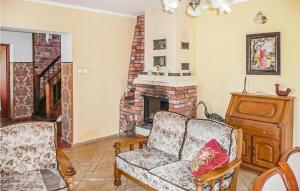 a living room with a couch and a fireplace at Nice Home In Pl-76-113 Postomino in Korlino