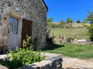 a stone house with a white door and a window at Le col de Perjuret in Fraissinet-de-Fourques