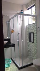 y baño con ducha y mampara de cristal. en Apartamento à beira mar Praia de Unamar en Cabo Frío