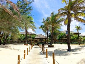 un camino que conduce a una playa con palmeras en Resort VG SUN por Be My Guest! en Caucaia