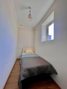 um pequeno quarto com uma cama e uma janela em Luxury Apartment in Tbilisi City Centre em Tbilisi