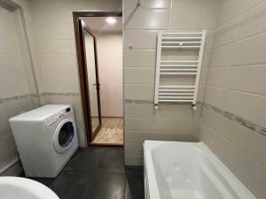 a bathroom with a washing machine and a bath tub at Luxury Apartment in Tbilisi City Centre in Tbilisi City