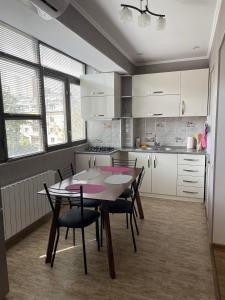 Luxury Apartment in Tbilisi City Centre في تبليسي: مطبخ مع طاولة وكراسي في غرفة