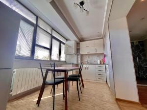 Luxury Apartment in Tbilisi City Centre في تبليسي: مطبخ مع طاولة وكراسي في غرفة